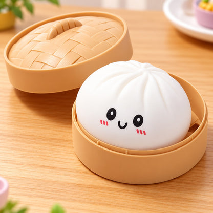 A cute white steamed bun-shaped item with a smiling face sits inside a tan round steamer basket on a wooden table, with the matching lid placed behind it.