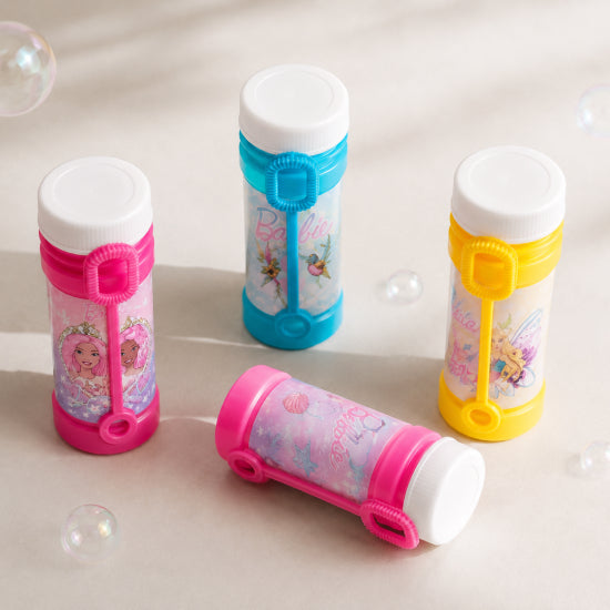 Four bubble bottles with white caps arranged on a light beige surface with floating soap bubbles. Three bottles stand upright, two are pink and one is blue, and one bottle lies on its side.