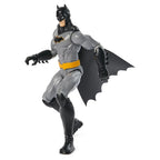 Batman action figure with gray suit, black cape, and yellow belt on a white background