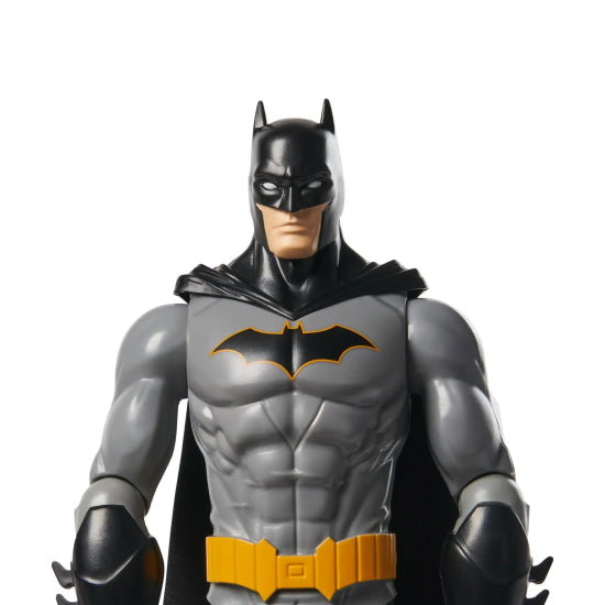 Batman action figure with gray suit, black cape, and yellow belt on a white background